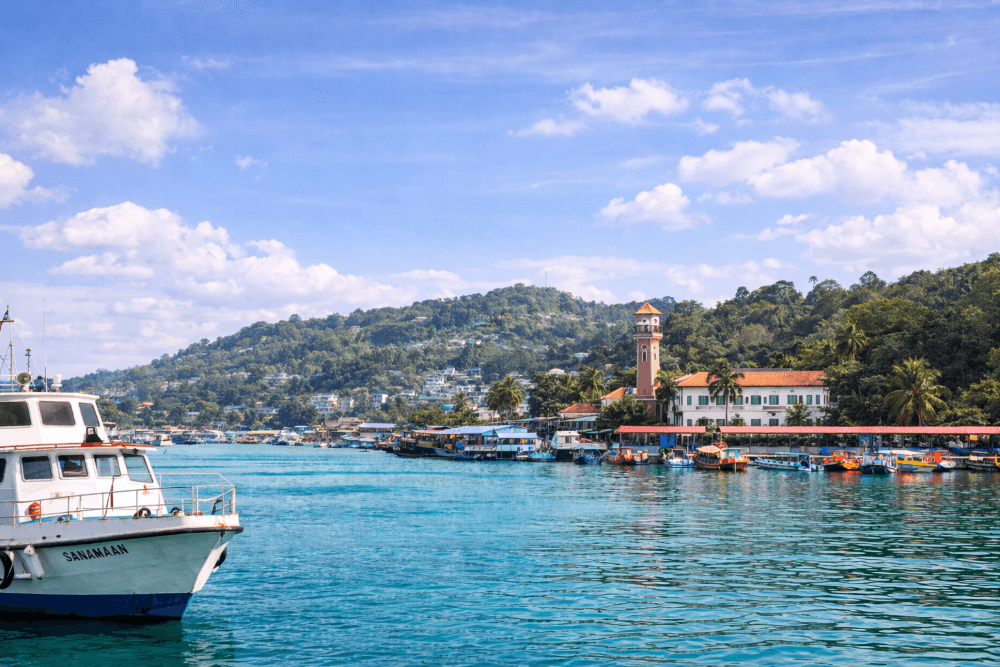 Beautiful harbour view of Port Blair, the gateway to the Andaman and Nicobar Islands, featuring turquoise water, boats and tropical hills.